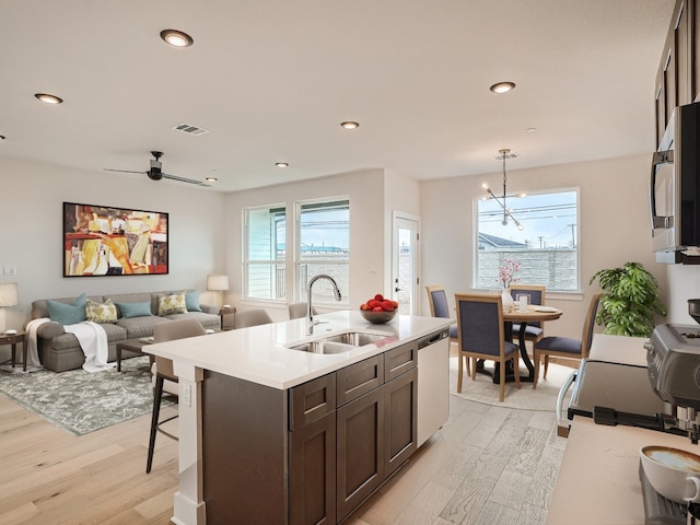 2600 Gattis School Rd Unit 401, Round Rock, TX 78664 - kitchen featuring a sink, light wood-type flooring, stainless steel appliances, dark brown cabinets, and light countertops