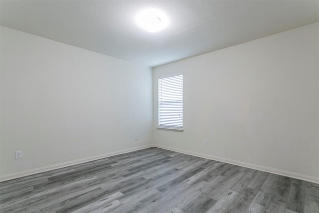 empty room with wood finished floors and baseboards