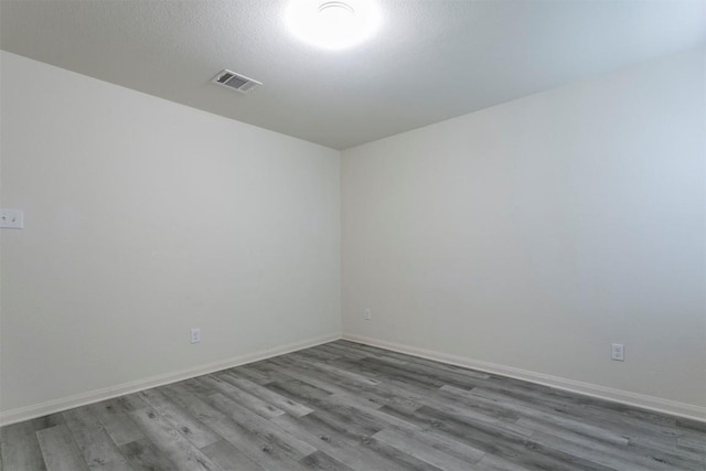 spare room with wood finished floors and baseboards