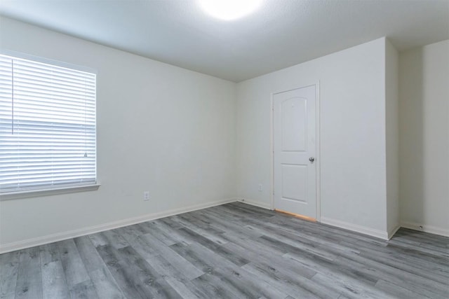 unfurnished room with wood finished floors and baseboards