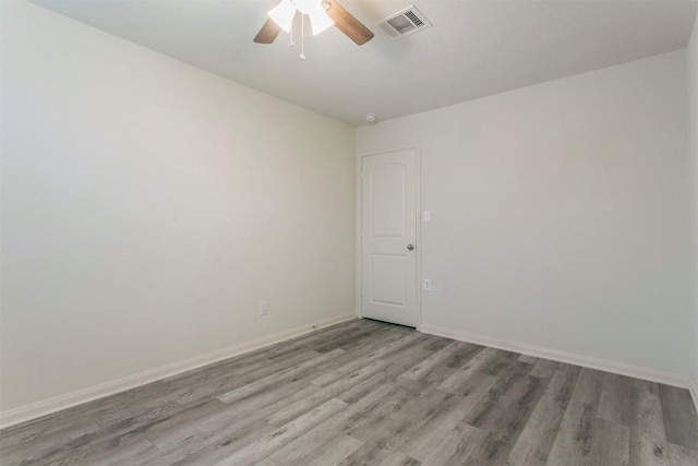 empty room with wood finished floors, ceiling fan, and baseboards