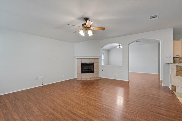 4329 Rock Hill Rd, Round Rock, TX 78681 - unfurnished living room featuring a ceiling fan, arched walkways, wood finished floors, and a fireplace