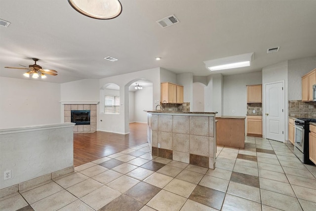 4329 Rock Hill Rd, Round Rock, TX 78681 - kitchen featuring stainless steel gas range oven, tasteful backsplash, light brown cabinetry, light tile patterned floors, and a ceiling fan
