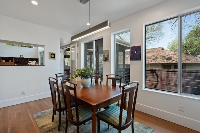 dining room with baseboards, wood finished floors, and recessed lighting