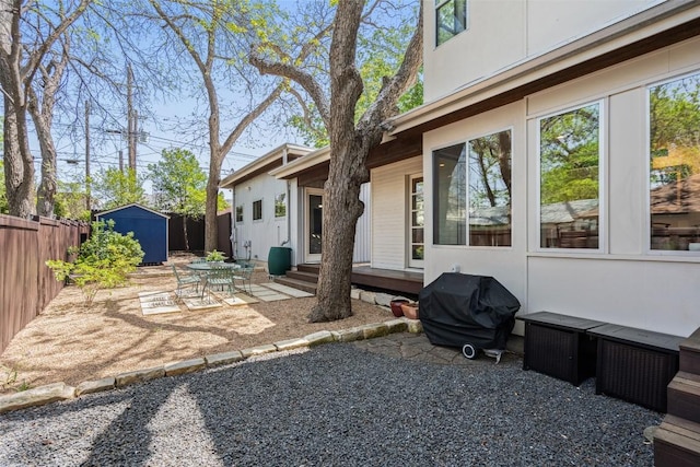 view of yard featuring a shed, a patio, fence, and an outdoor structure