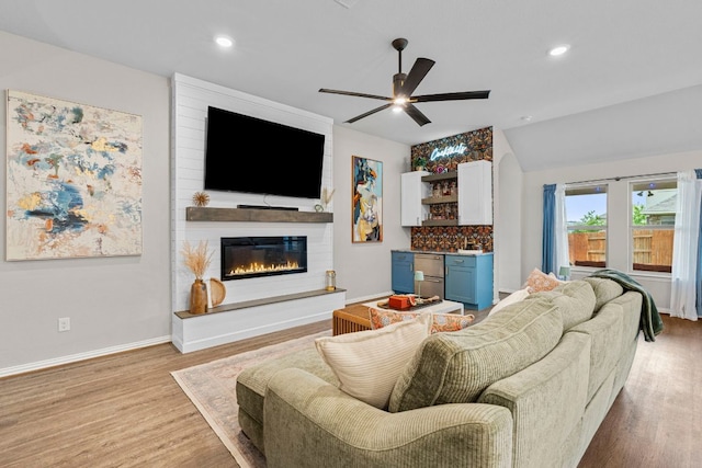 115 Oleander Loop, Buda, TX 78610 - living area with wood finished floors, a ceiling fan, a large fireplace, and recessed lighting