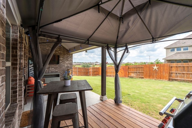 115 Oleander Loop, Buda, TX 78610 - deck featuring an outdoor brick fireplace and a fenced backyard