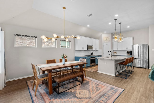 115 Oleander Loop, Buda, TX 78610 - dining space with a chandelier, wood finished floors, recessed lighting, and vaulted ceiling
