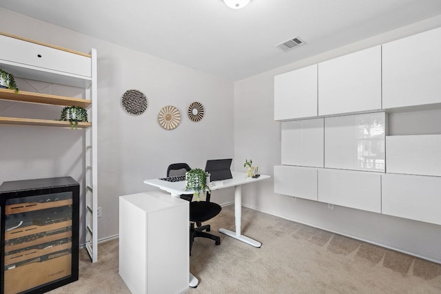 office space featuring light carpet, wine cooler, and baseboards