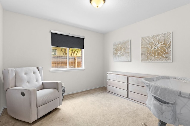 sitting room featuring light colored carpet and baseboards