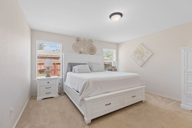 bedroom with light carpet and baseboards
