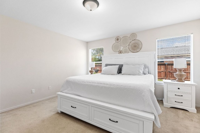 bedroom with light colored carpet and baseboards