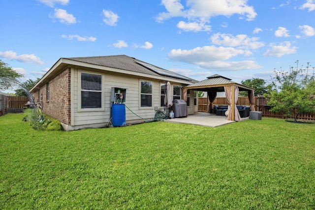 back of house featuring a patio area, a gazebo, solar panels, brick siding, and central AC