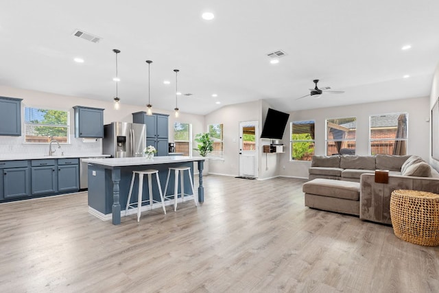 kitchen featuring stainless steel appliances, light countertops, blue cabinetry, healthy amount of natural light, and recessed lighting