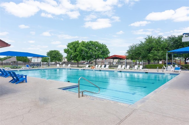 community pool with fence and a patio area