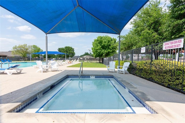 community pool with fence and a patio
