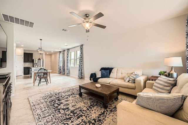 living room with a ceiling fan, baseboards, recessed lighting, and light tile patterned floors