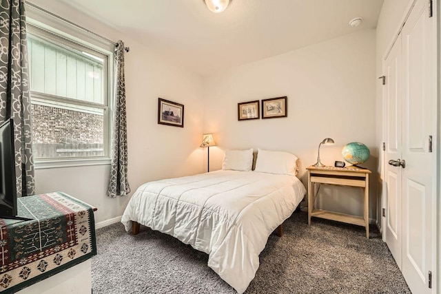 carpeted bedroom with a closet and baseboards