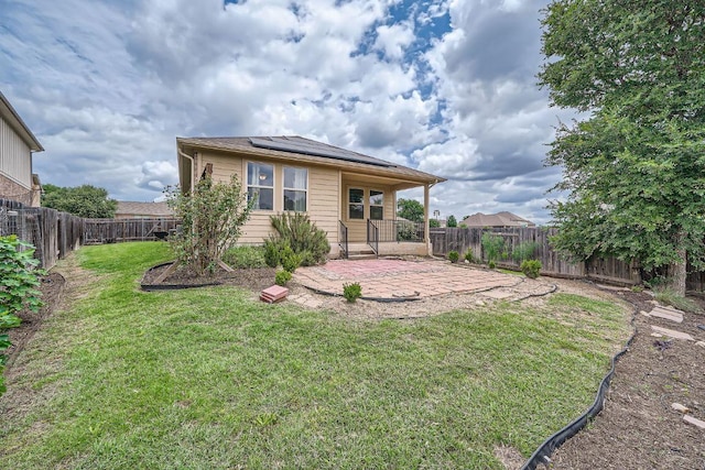 rear view of house featuring a patio and solar panels