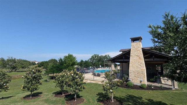 view of home's community featuring a lawn and a pool