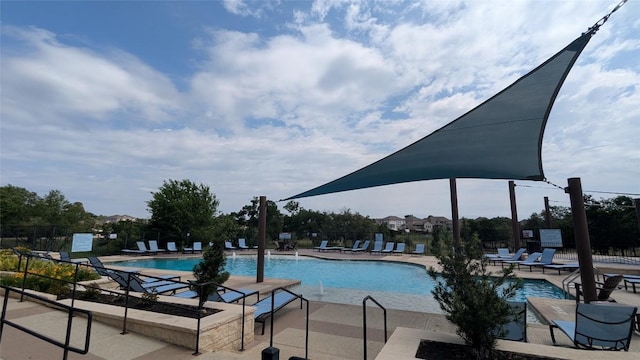community pool with a patio and fence