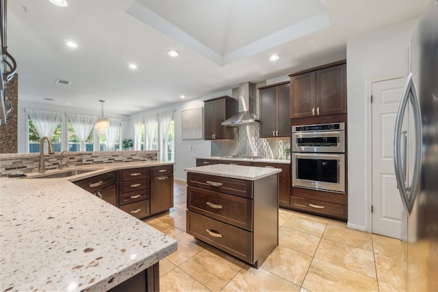 3016 Sunland Dr, Austin, TX 78748 - kitchen featuring wall chimney exhaust hood, appliances with stainless steel finishes, backsplash, a kitchen island, and recessed lighting