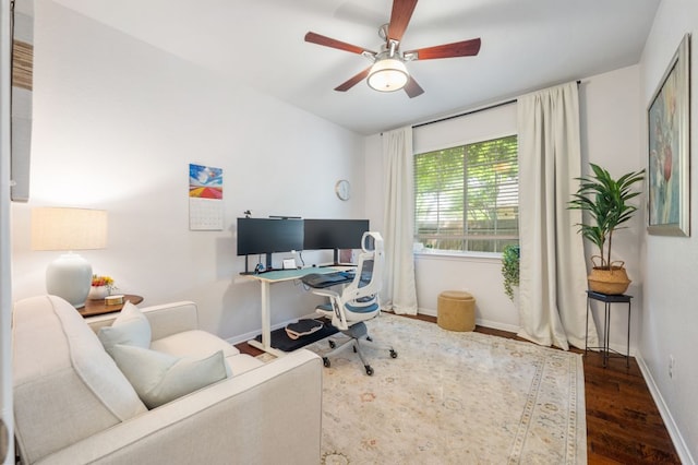 office space with wood finished floors, a ceiling fan, and baseboards
