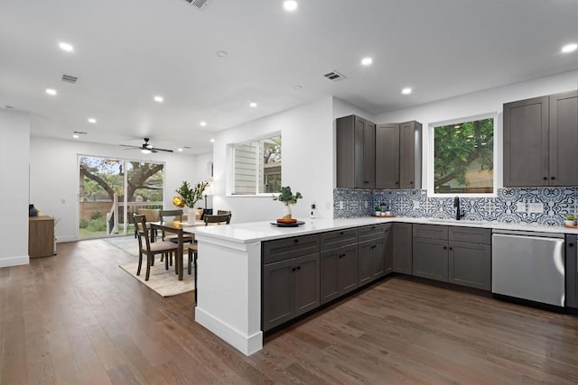 1208 W Oltorf St Unit B, Austin, TX 78704 - kitchen with stainless steel dishwasher, a peninsula, gray cabinetry, a sink, and tasteful backsplash