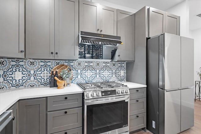 1208 W Oltorf St Unit B, Austin, TX 78704 - kitchen featuring stainless steel appliances, gray cabinetry, under cabinet range hood, and tasteful backsplash