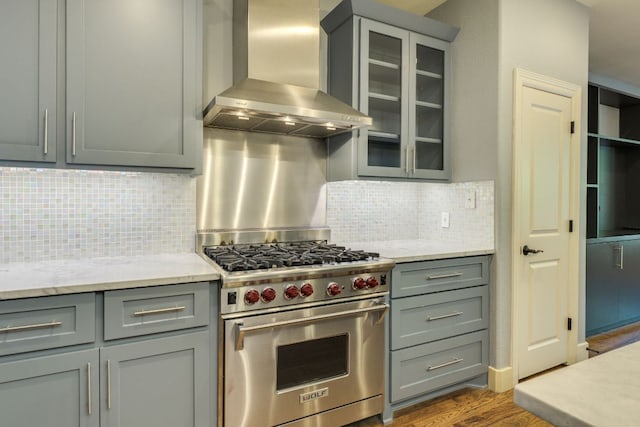 2112 W 11th St, Austin, TX 78703 - kitchen with premium range, wall chimney exhaust hood, gray cabinetry, dark wood-type flooring, and tasteful backsplash