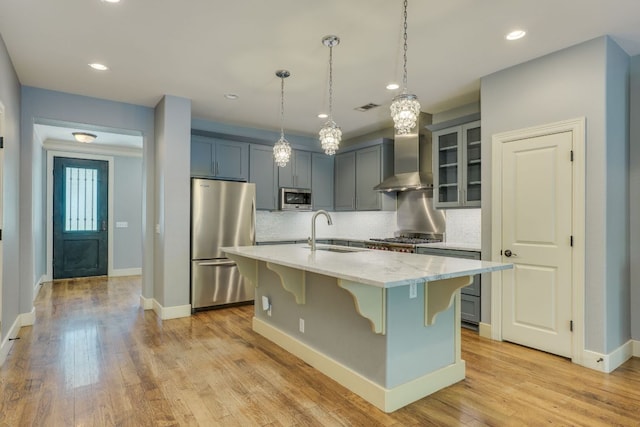 2112 W 11th St, Austin, TX 78703 - kitchen with stainless steel appliances, a sink, wall chimney exhaust hood, a kitchen bar, and decorative backsplash