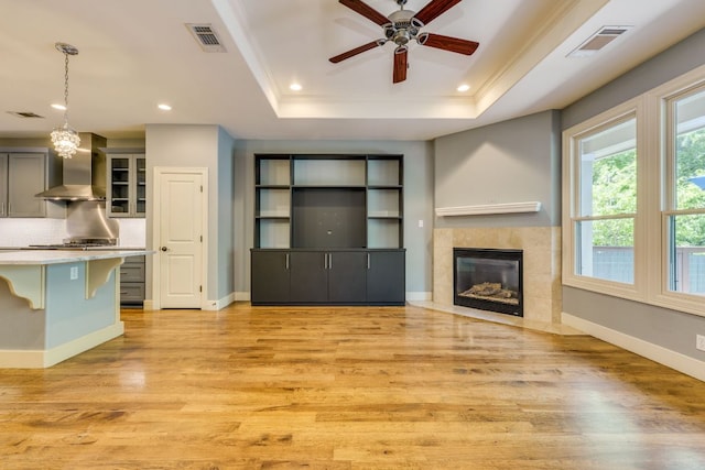 2112 W 11th St, Austin, TX 78703 - unfurnished living room with a raised ceiling, light wood-style flooring, ceiling fan, recessed lighting, and ornamental molding