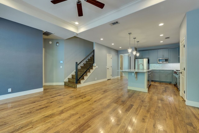 2112 W 11th St, Austin, TX 78703 - kitchen featuring stainless steel appliances, ceiling fan, light countertops, ornamental molding, and backsplash