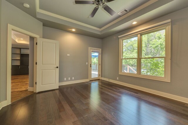 2112 W 11th St, Austin, TX 78703 - spare room with a tray ceiling, dark wood-type flooring, crown molding, a smoke detector, and a ceiling fan