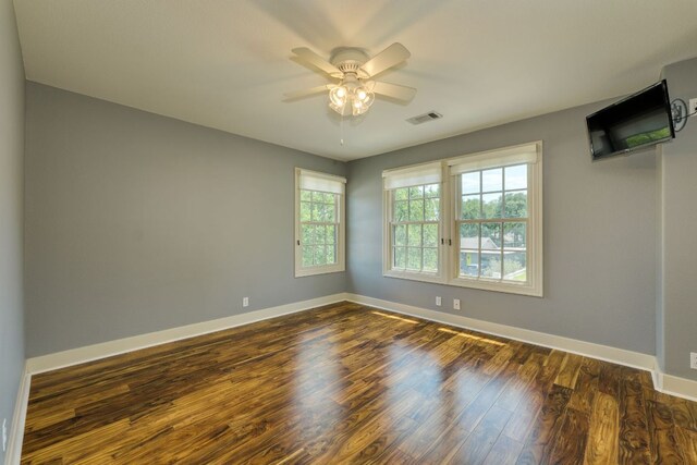2112 W 11th St, Austin, TX 78703 - empty room with dark wood-type flooring, baseboards, and a ceiling fan
