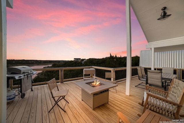 693 Riviera Dr, Canyon Lake, TX 78133 - deck at dusk with an outdoor fire pit and grilling area