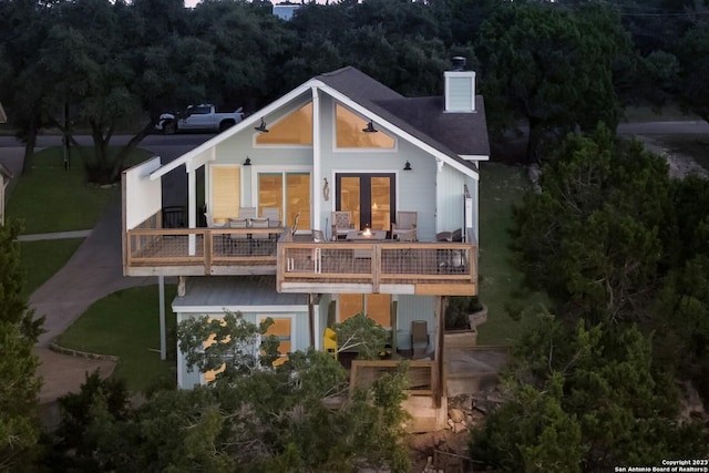 693 Riviera Dr, Canyon Lake, TX 78133 - back of house featuring a balcony, a chimney, a lawn, and a shingled roof