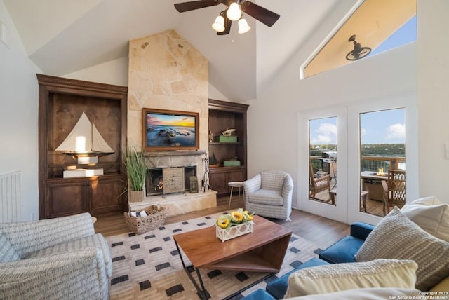 693 Riviera Dr, Canyon Lake, TX 78133 - living area with wood finished floors, a premium fireplace, ceiling fan, high vaulted ceiling, and built in features
