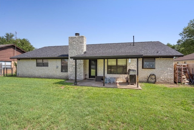 rear view of house with a chimney, a patio, roof with shingles, and brick siding
