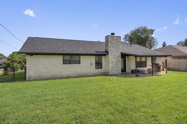 rear view of house featuring a patio area, a chimney, roof with shingles, and brick siding