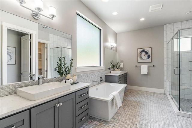 27 Wingreen Loop, The Hills, TX 78738 - bathroom with a stall shower, two vanities, a bath, recessed lighting, and decorative backsplash