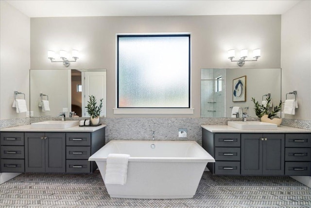 27 Wingreen Loop, The Hills, TX 78738 - bathroom featuring a freestanding bath, two vanities, and a stall shower