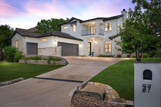 27 Wingreen Loop, The Hills, TX 78738 - modern home with a balcony, stone siding, a garage, stucco siding, and a lawn
