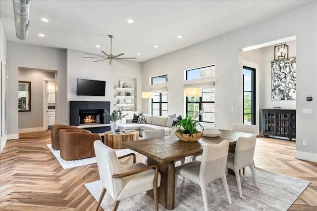 27 Wingreen Loop, The Hills, TX 78738 - dining space featuring healthy amount of natural light, recessed lighting, a warm lit fireplace, built in features, and a ceiling fan