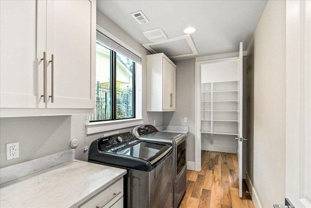 27 Wingreen Loop, The Hills, TX 78738 - laundry room with cabinet space, washer and dryer, and light wood-style floors