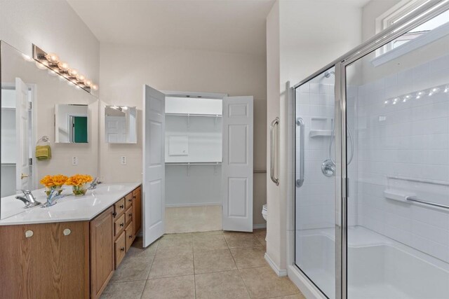 233 Crockett Loop, Georgetown, TX 78633 - full bath with a shower stall, double vanity, a spacious closet, tile patterned flooring, and toilet