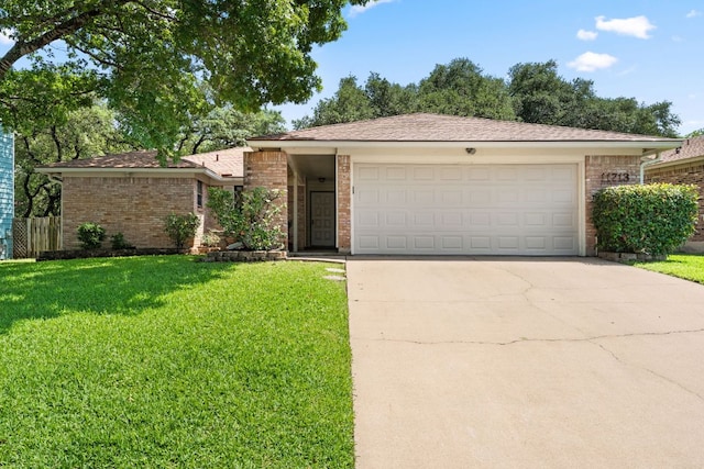 view of front facade with a front yard, concrete driveway, a garage, and brick siding
