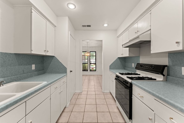 kitchen with black gas stove, light tile patterned flooring, white cabinets, under cabinet range hood, and recessed lighting