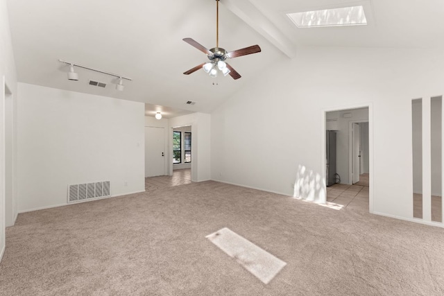 carpeted spare room featuring a skylight, a ceiling fan, beamed ceiling, rail lighting, and high vaulted ceiling
