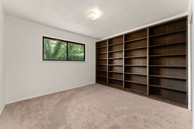 spare room featuring carpet floors and baseboards